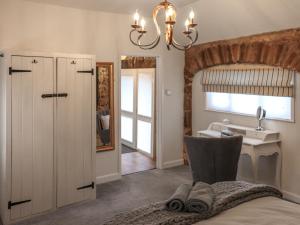 a bathroom with a sink and a bed and a mirror at Stable End in Llandysul +7 photos