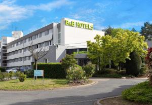 a building with a sign for a bag hotel at B&B HOTEL Cergy Port 4 étoiles in Cergy
