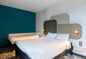 two beds in a room with green walls at B&B HOTEL Rouen Centre Rive Gauche in Rouen