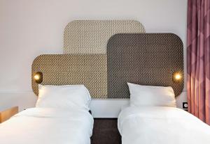 two beds in a room with a headboard at B&B HOTEL Rouen Centre Rive Gauche in Rouen +26 photos