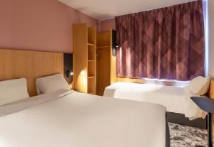 a hotel room with two beds and a window at B&B HOTEL Amiens Centre Cathédrale in Amiens