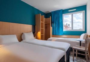 a room with two beds and a window at B&B HOTEL Amiens Centre Cathédrale in Amiens