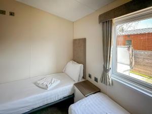 a small room with two beds and a window at Dorado Cottage - Uk49469 in Morpeth