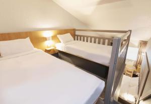 a small room with two beds and a lamp at B&B HOTEL Bayonne in Bayonne