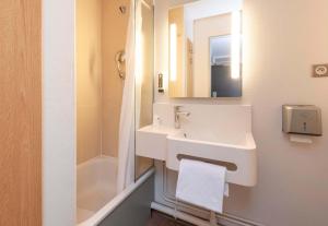 a white bathroom with a sink and a shower at B&B HOTEL Bayonne in Bayonne