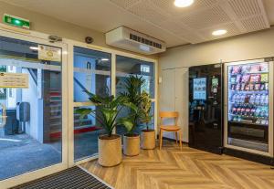 a store front with two potted plants and a chair at B&B HOTEL Bayonne in Bayonne +18 photos