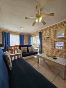 a living room with a couch and a ceiling fan at 28 Kabeljauws in Jeffreys Bay