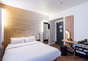a hotel room with a bed and a desk at B&B HOTEL Lille Villeneuve d'Ascq Grand Stade 3 étoiles in Villeneuve d'Ascq
