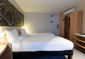 a large white bed in a hotel room at B&B HOTEL Reims Centre Erlon in Reims