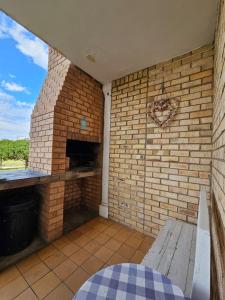 a brick patio with a bench and a brick wall at 28 Kabeljauws in Jeffreys Bay