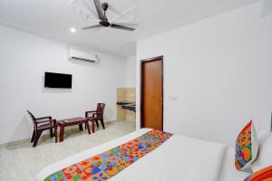 a bedroom with a bed and a room with a tv at FabHotel HR Residency in New Delhi
