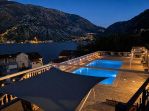 a swimming pool on a balcony with a view of a lake at Kotor Bay View Residence with Pool in Muo