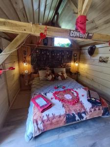 a bedroom with a large bed in a cabin at Ptit Ranch "Ô Rêves Atypiques" spa privatif in Boucé