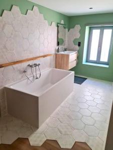 a large white tub in a bathroom with a sink at Les 3 suites in Issoire +12 photos