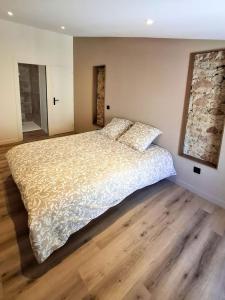 a bedroom with a large bed and wooden floors at Les 3 suites in Issoire