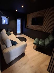a living room with a white couch and a tv at Les 3 suites in Issoire