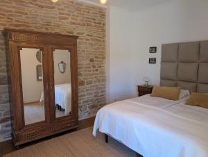 a bedroom with a mirror next to a bed at Maison Mazille in Mazille