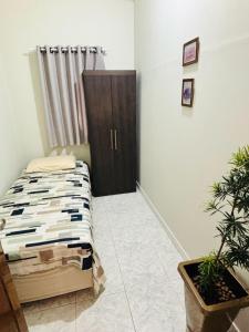 a bedroom with a bed and a cabinet at Pousada e Pensionato Consuelo in Montes Claros