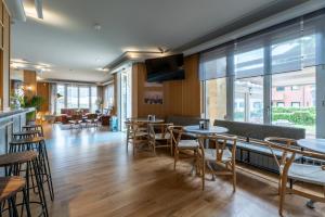 a restaurant with tables and chairs and windows at Hotel Silken Don Pepe y Don Pepe Ría in Ribadesella