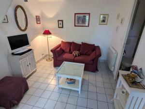 a living room with a red couch and a tv at Maisonnette Piriac-sur-Mer in Piriac-sur-Mer