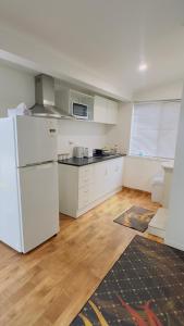a kitchen with a white refrigerator in a room at Private Guest Studio House, Separate Entry in Brisbane