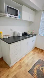 a kitchen with white cabinets and a microwave at Private Guest Studio House, Separate Entry in Brisbane +8 photos