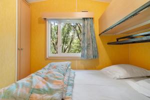 a bedroom with a bed and a window at 23.Mobil-home option clim-5pers in Calviac