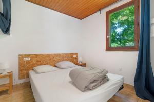 a bedroom with a white bed and a window at 16. Les Sources option clim- 2 pers in Calviac