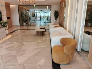 a lobby with couches and tables in a building at Voyage Expo Suites in Riyadh