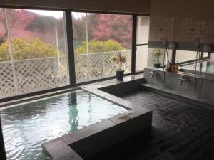 a swimming pool in a room with a large window at Utsunomiya Inter Resort Hotel & Golf Tsuru Country Club in Utsunomiya