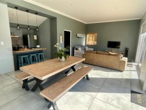 a living room with a wooden table and a couch at The Kite Cottage in Langebaan