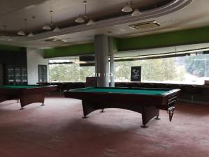 a billiard room with two pool tables and couches at Utsunomiya Inter Resort Hotel & Golf Tsuru Country Club in Utsunomiya