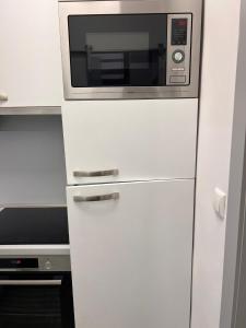 a microwave sitting on top of a white refrigerator at Centrum Apartman LEYLA 8 in Bardejov