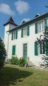 a white house with green shutters and a yard at Studio lumineux & calme à Biarritz - Parking privé gratuit in Biarritz