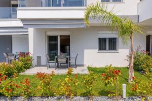 a house with a patio with a table and chairs at Green Almond's Comfort Apartment in Orfánion