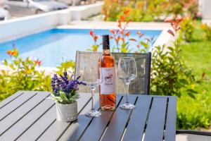 a bottle of wine sitting on a table with two wine glasses at Green Almond's Comfort Apartment in Orfánion