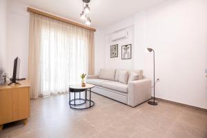 a living room with a couch and a table at Green Almond's Comfort Apartment in Orfánion