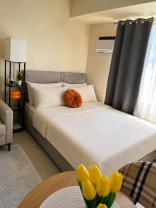 a bedroom with a large bed with yellow tulips at The Nook at Avida Towers 2 CDO in Cagayan de Oro
