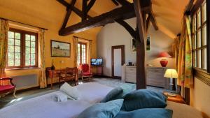 a bedroom with a large bed and a desk at Les Maisons de Mélody in Houlbec-Cocherel