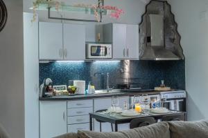 a kitchen with white cabinets and a table in it at Elissavet Maison in Perea
