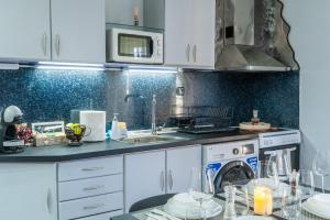a kitchen with white cabinets and a sink and a dishwasher at Elissavet Maison in Perea