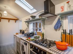 a kitchen with a stove and a washing machine at Flint Cottage in Saxmundham