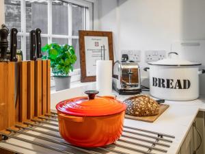 an orange pot sitting on top of a kitchen counter at Flint Cottage in Saxmundham