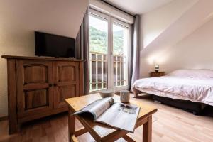 a bedroom with a bed and a tv and a table at Studio 766 – LA TARENTAISE in Brides-les-Bains