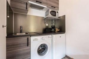 a kitchen with a washing machine and a sink at Studio 766 – LA TARENTAISE in Brides-les-Bains