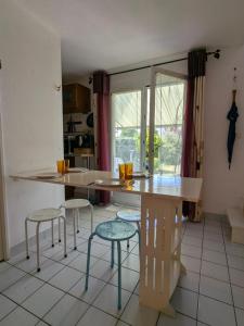 a kitchen with a table and stools in a room at Maisonnette Piriac-sur-Mer in Piriac-sur-Mer