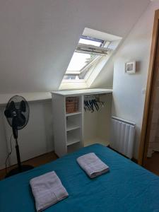 a bedroom with a bed with blue sheets and a skylight at Maisonnette Piriac-sur-Mer in Piriac-sur-Mer +10 photos