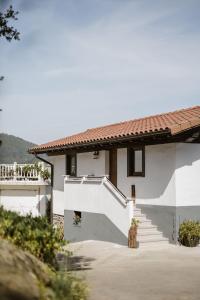 a white house with stairs and a roof at Arriola Txiki in Itziar