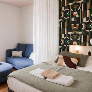 a bedroom with a bed and a blue couch at Charmant Studio au cœur de Dinard in Dinard +17 photos