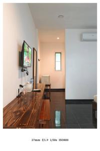 ein Wohnzimmer mit einem Holztisch und einem Fernseher an der Wand in der Unterkunft king s hotel in Mae Sot